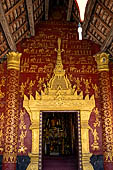 Luang Prabang, Laos - Wat Si Boun Huang, the main door is decorated with a gilded high reliefs in the shape of a stupa among stencilled gilded apsaras. 